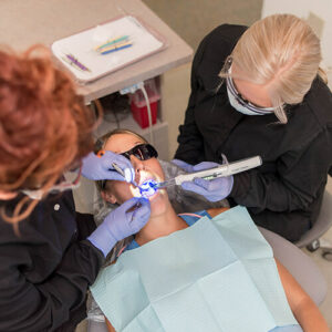 New Patient - Patient Woman is being checked by two assistants at Eleven Eleven Dental