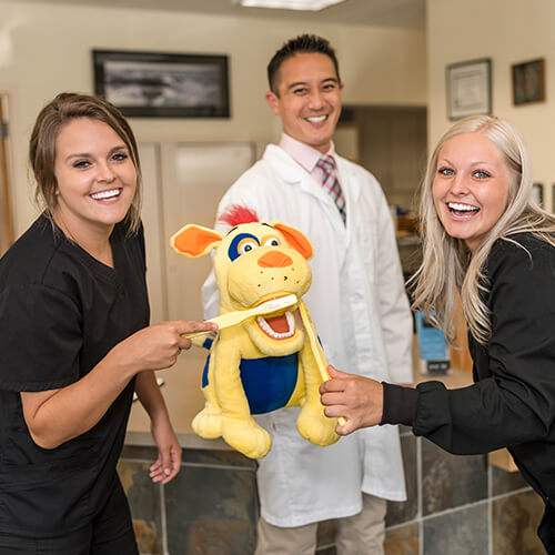 two-assistants-and-the-doctor-playing-with-a-stuffed-dog